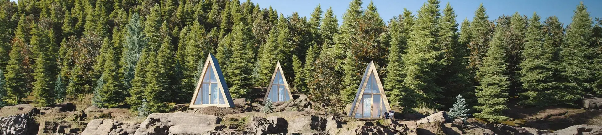 Aerial view of multiple modern cabins arranged in clusters within a forest resort